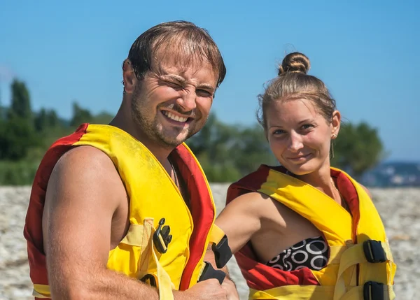 Paar zieht Schwimmweste am Strand an — Stockfoto