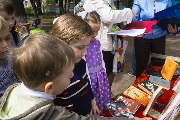 Children consider books and children drawings about war in park — Stock Photo, Image