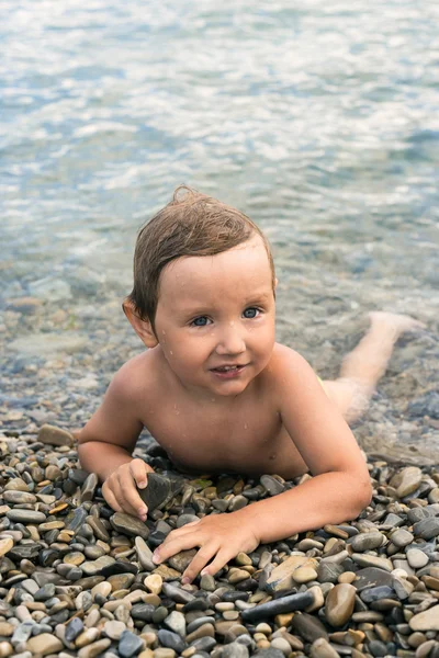 Three year boy bathes in the sea on pebbles — Stock Photo, Image