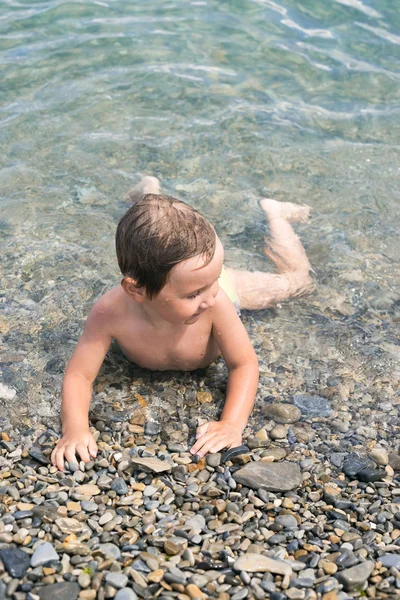 Drie jaar jongen baadt in de zee op keien — Stockfoto