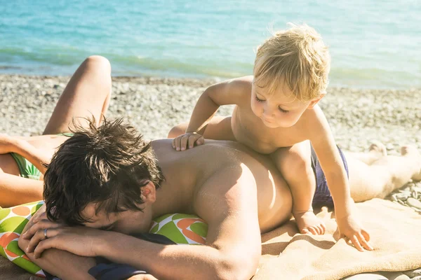 Rozcuchaný unavený otec nechce hrát s dítětem na pláži — Stock fotografie