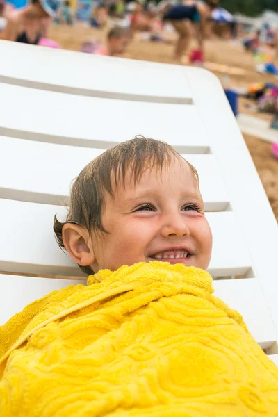 Szép kis fiú, csomagolva sárga törülközőt strandon portréja — Stock Fotó