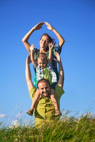 Família feliz de três pessoas se divertir ao ar livre — Fotografia de Stock