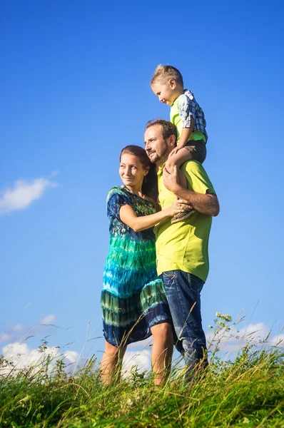 Família feliz de três pessoas se divertir ao ar livre — Fotografia de Stock