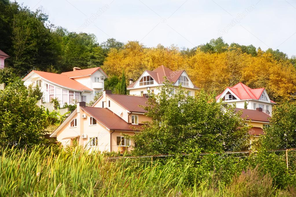 Cottage houses in picturesque autumn forest