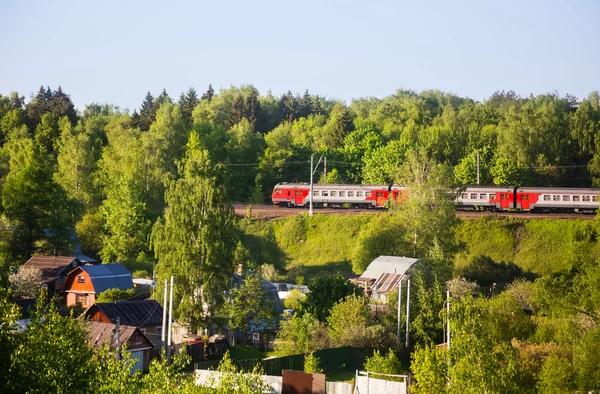 Железнодорожный поезд проходит мимо деревни отдыха Стоковое Изображение