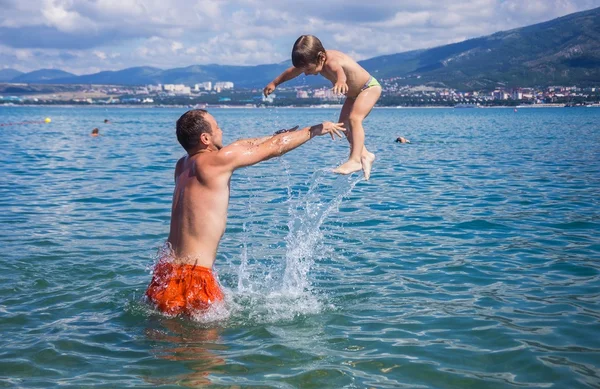 Táta s mladým synem, koupání v moři — Stock fotografie