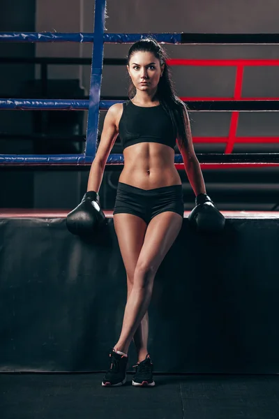Donna che indossa guanti da boxe seduta vicino al ring — Foto Stock