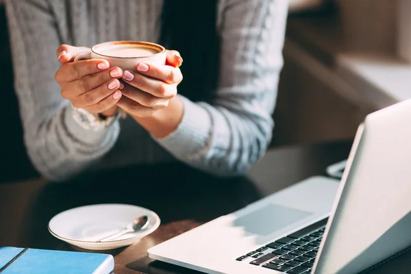 Vrouw houdt warme kop koffie, opwarming van de aarde haar handen — Stockfoto