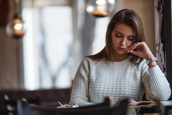 Mujer leyendo libro en la cafetería cerca de ventana —  Fotos de Stock