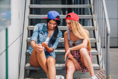 iki mutlu kız merdivende sohbet