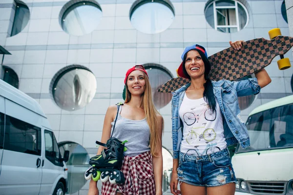 iki genç kızlar longboard ve patenler ile daimi