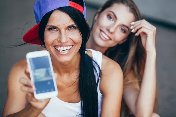 Dos mujeres adultas jóvenes con smartphone —  Fotos de Stock