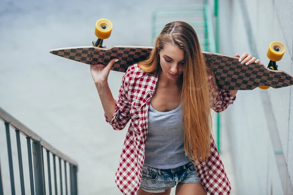 Jeune belle femme avec longboard — Photo