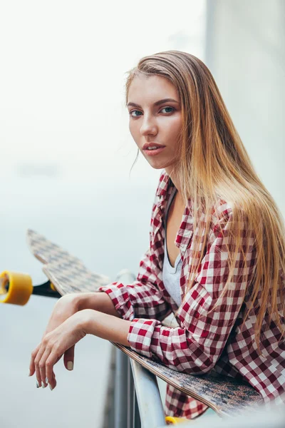 Ung vacker kvinna med longboard — Stockfoto