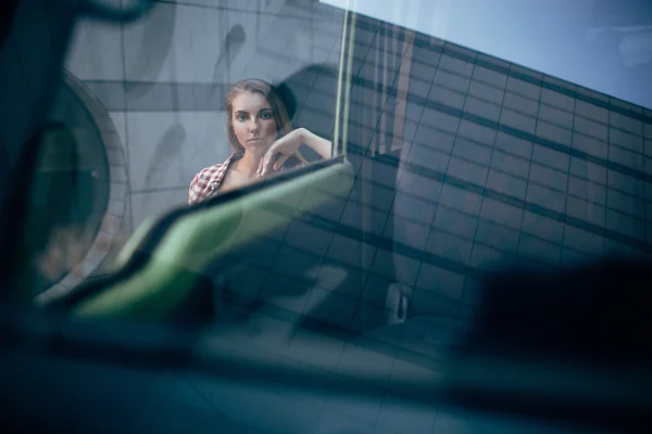 Joven mujer mirando lejos a través del vidrio — Foto de Stock