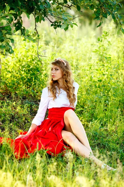 Portrait of blonde woman sitting under the tree — Stock Photo, Image