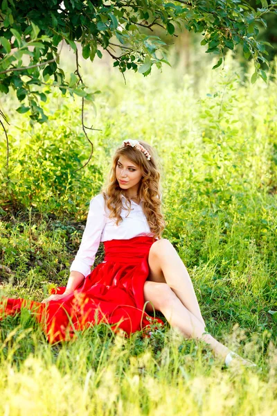 Portrait of blonde woman sitting under the tree — Stock Photo, Image