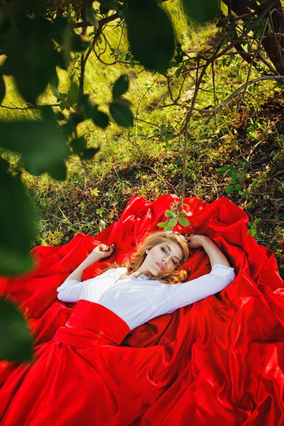 Woman in red skirt lying under the tree — Stock Photo, Image