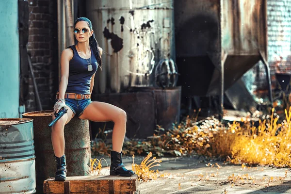 Sexy mujer usando gafas de sol sosteniendo la pistola — Foto de Stock