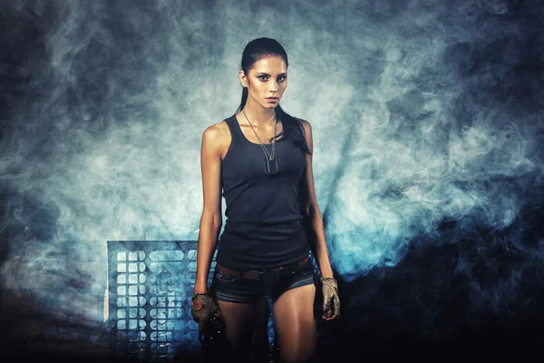 Sexy woman standing on ruins and holding handgun — Stock Photo, Image