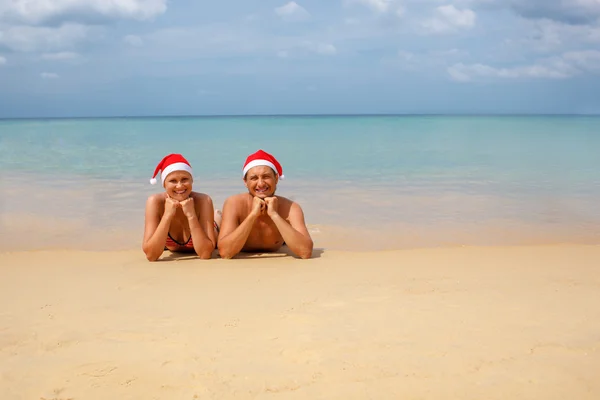 Para w czerwone kapelusze Santa na tropikalnej plaży — Zdjęcie stockowe