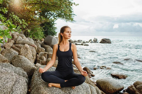 Women doing yoga with the ocean behind — Stock Photo, Image