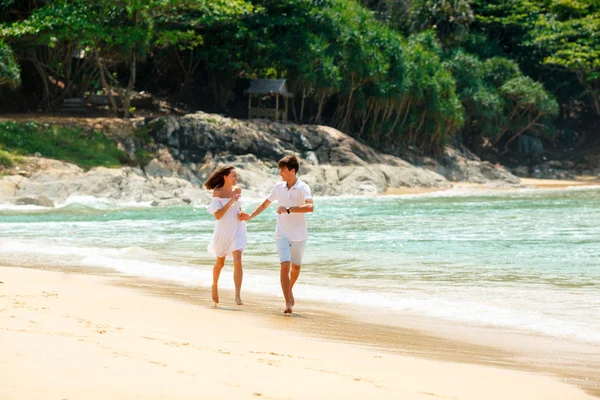 Casal feliz correndo na praia tropical — Fotografia de Stock