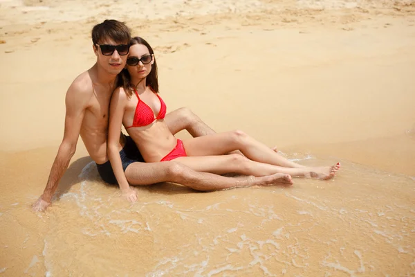 Joyeux couple en lunettes de soleil sur la plage — Photo