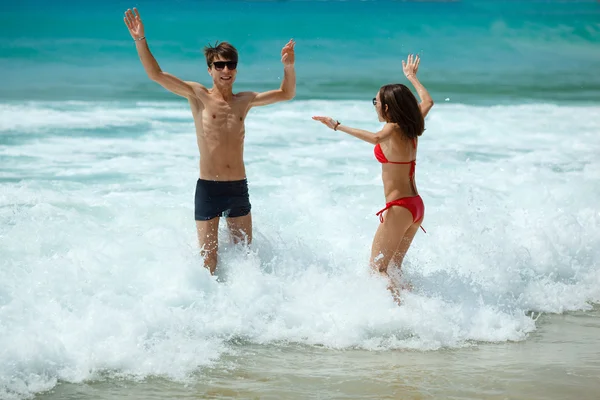 Casal feliz em óculos de sol na praia — Fotografia de Stock