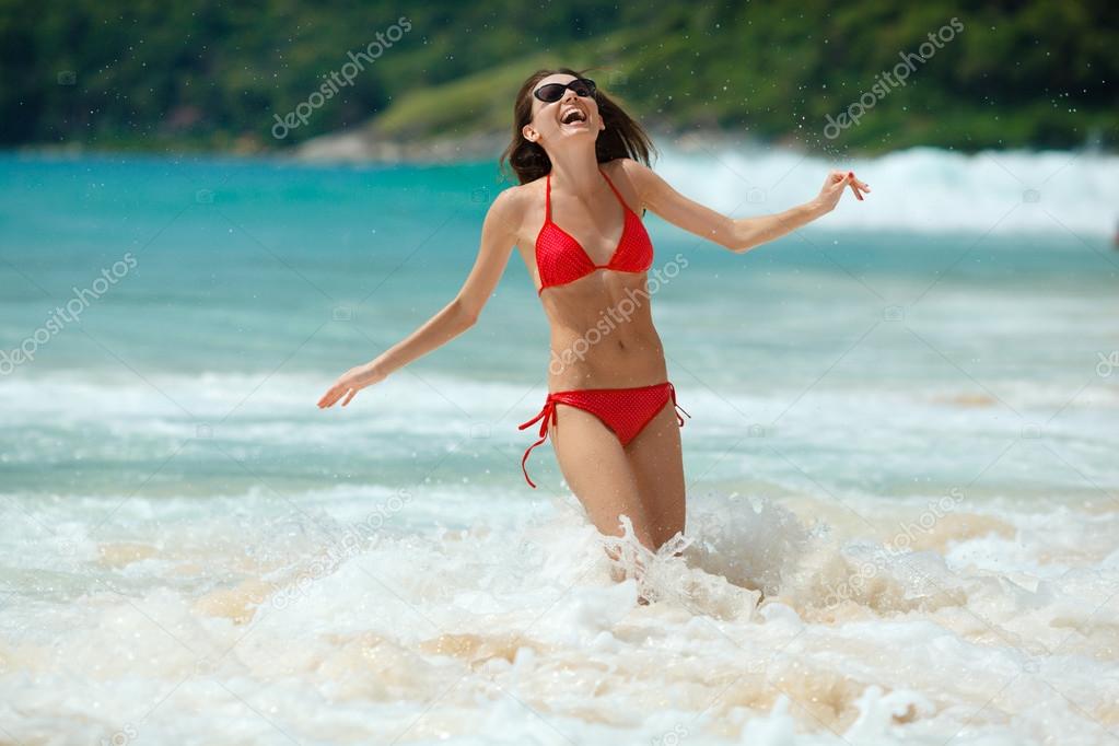 happy woman wearing sunglasses in water