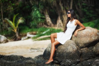 taş üzerine oturan güzel tabaklanmış kadın