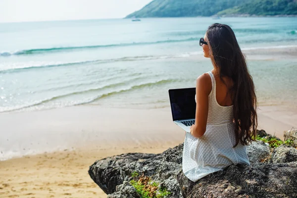 Frau sitzt mit Laptop auf dem Felsen — Stockfoto