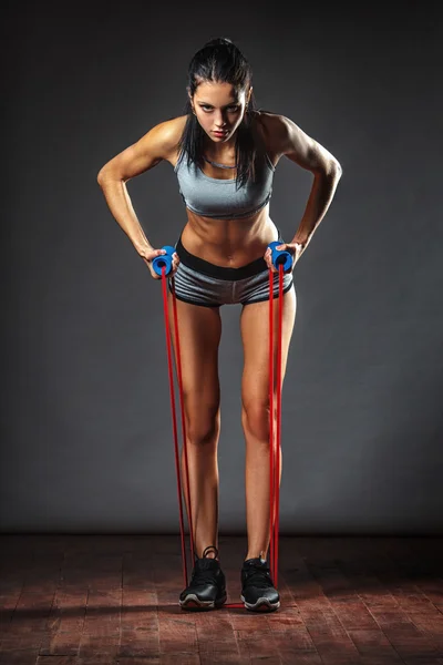 Woman exercising with rubber tape Royalty Free Stock Images