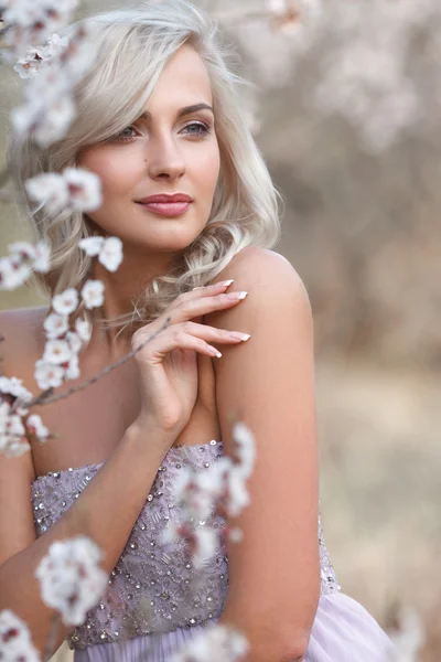 Femme blonde dans un jardin fleuri — Photo