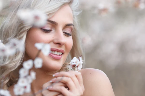 Blondýnka v rozkvetlé zahradě — Stock fotografie