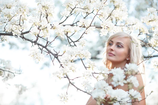 Blondýnka v rozkvetlé zahradě — Stock fotografie