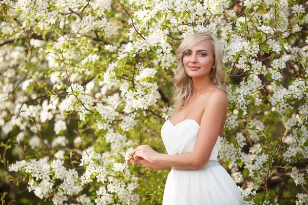 Blonde Frau in einem blühenden Garten — Stockfoto