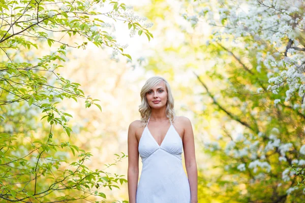 Junge Frau spaziert im Frühlingsgarten — Stockfoto