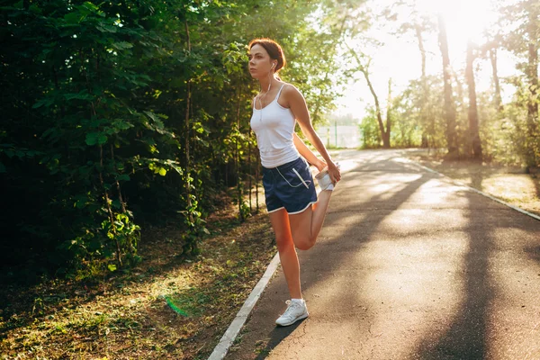 Yong sportovní žena streching nohu — Stock fotografie