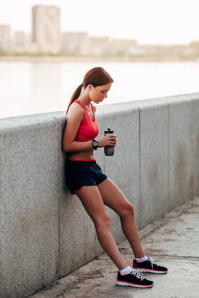 Kobiece kobieta lekkoatletka z butelkowanej wody — Zdjęcie stockowe