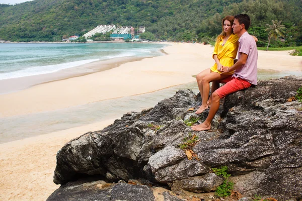 Casal observando o mar enquanto está em pé sobre uma rocha — Fotografia de Stock