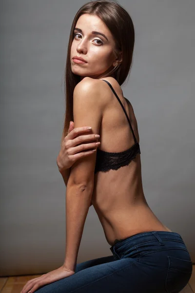 Model poses dragen beha met jeans — Stockfoto