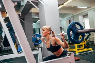 Bir spor salonunda fitness kadının halter yapması ağız kavgası