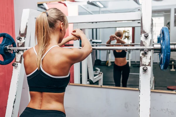 Mulher fitness preparando agachamentos barbell em um ginásio — Fotografia de Stock