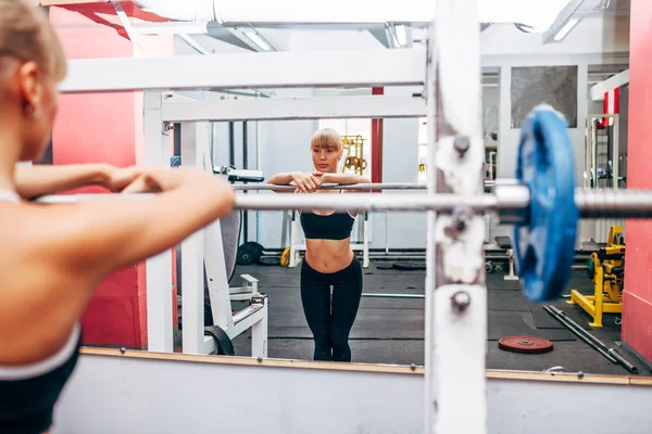 Femme de fitness préparant des squats d'haltères dans une salle de gym — Photo