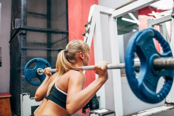 Fitness kobieta robi przysiady barbell w siłowni — Zdjęcie stockowe