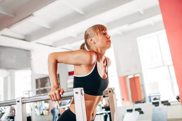 Woman doing dips in the gym — ストック写真