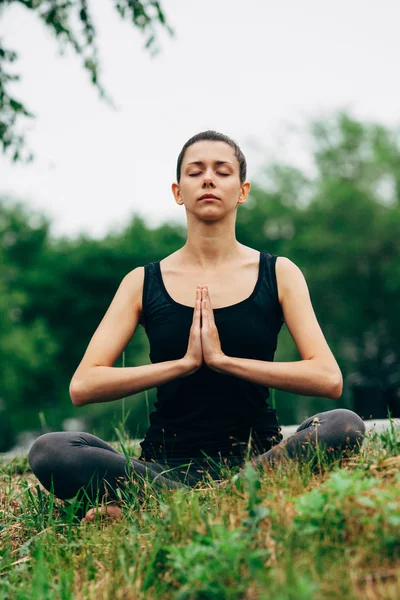 Woman sitting in lotus pose outdoors — ストック写真