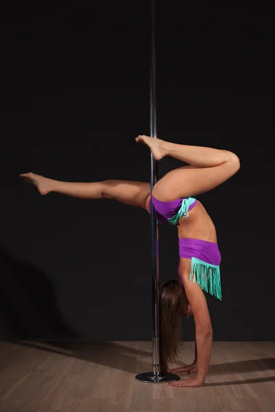 Mulher exercício pole dance no fundo cinza — Fotografia de Stock
